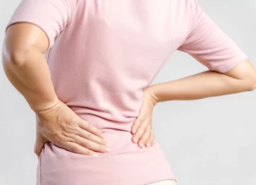 Perempuan Dewasa Memegang Pinggangnya Karena Mengalami Saraf Kejepit Karena Skoliosis Yang Dia Alami