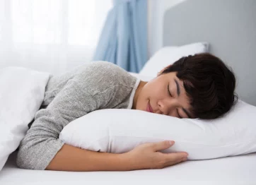 Wanita Berambut Pendek Tidur Tengkurap Meski Menderita Skoliosis