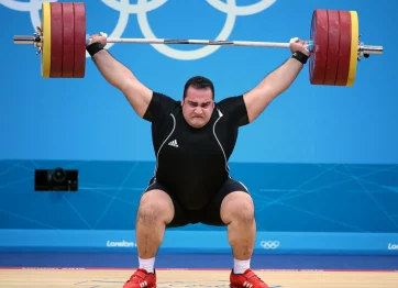 sedang mengangkat beban berat